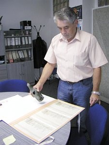 Fr. Alexa s rozbitou lahví a restaurovanými dokumenty